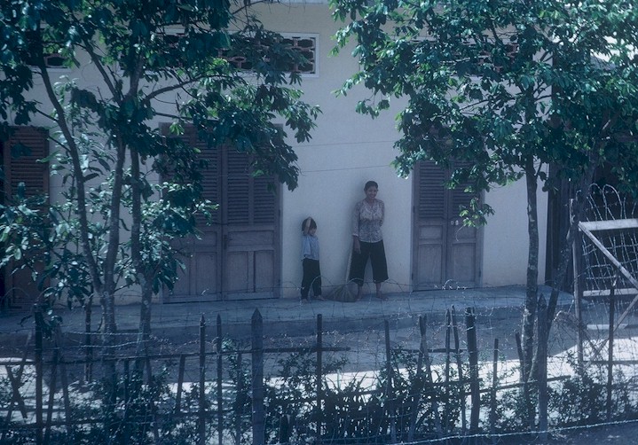 A child waves to us while her mother looks on.